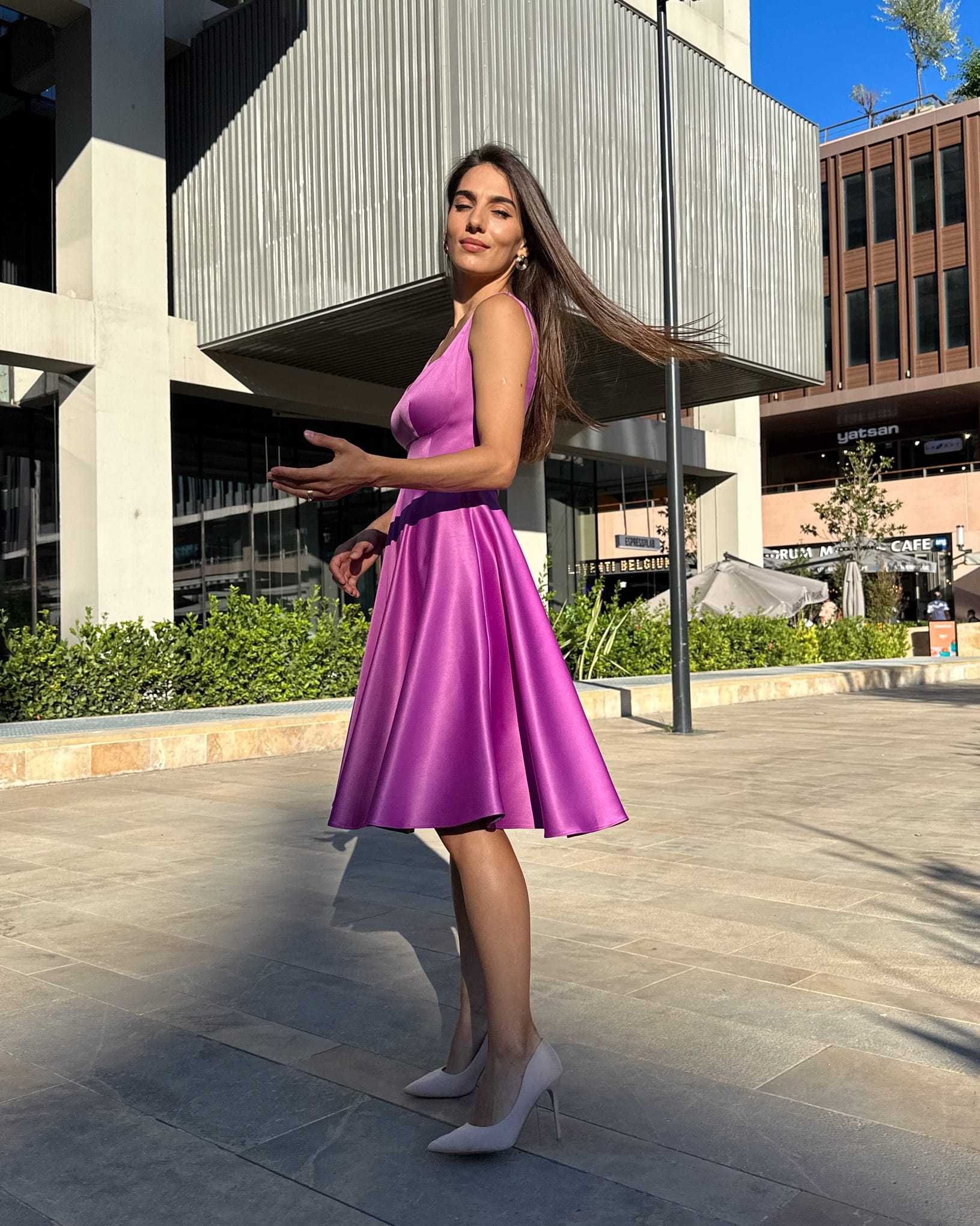 Rochie scurta mov evazată din satin, fără mâneci, decolteu ascuțit, eleganță urbană.