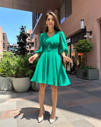 Rochie verde elegantă cu drapaj și mâneci, fermoar la spate.