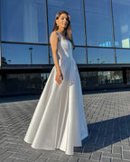 Rochie de mireasa alba lunga cu slit, elegantă și rafinată, potrivită pentru evenimente speciale.