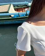 Rochie albă scurtă cloș cu mâneci semielastice, detalii feminine și elegante.