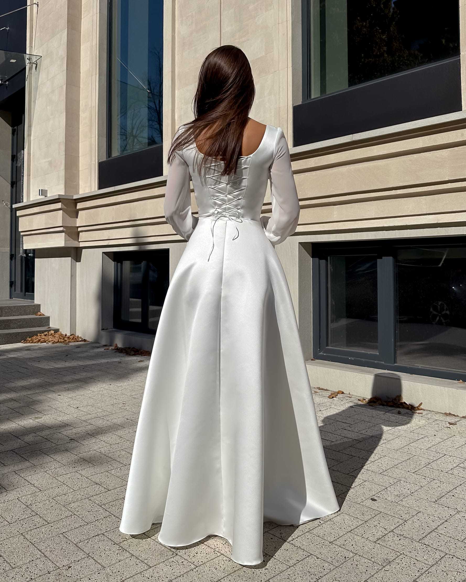 Rochie de mireasa lungă cu corset, mâneci semitransparente, sistem ajustare șnur, elegantă și modernă.