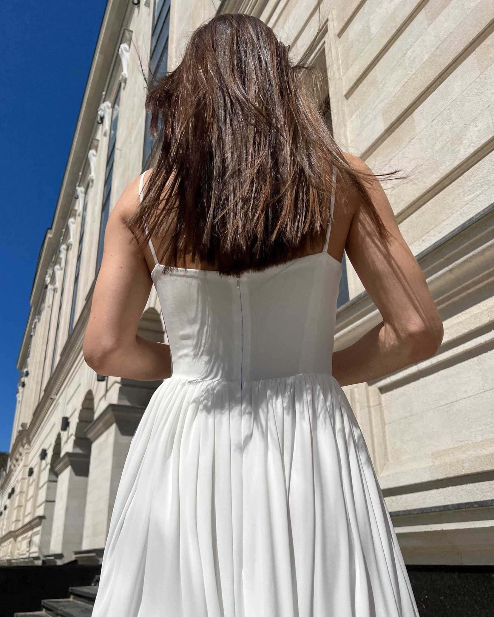 Rochie alba elegantă midi cu bretele și slit, evidențiere talie cu centură.