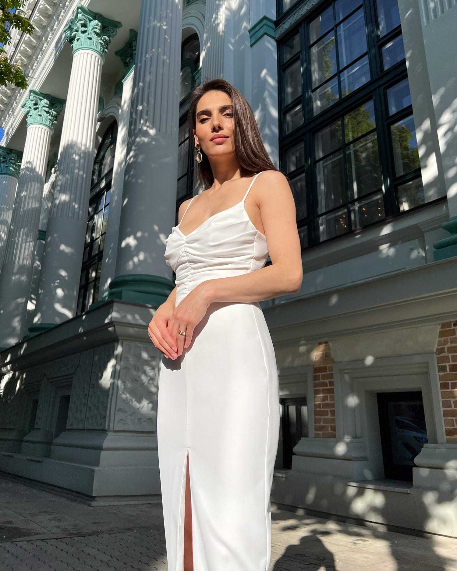 Rochie alba elegantă cu slit și bretele, design sofisticat pentru ocazii speciale.