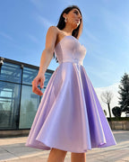 Rochie cu corset midi mov de ocazie și fustă evazată, purtată de o femeie.